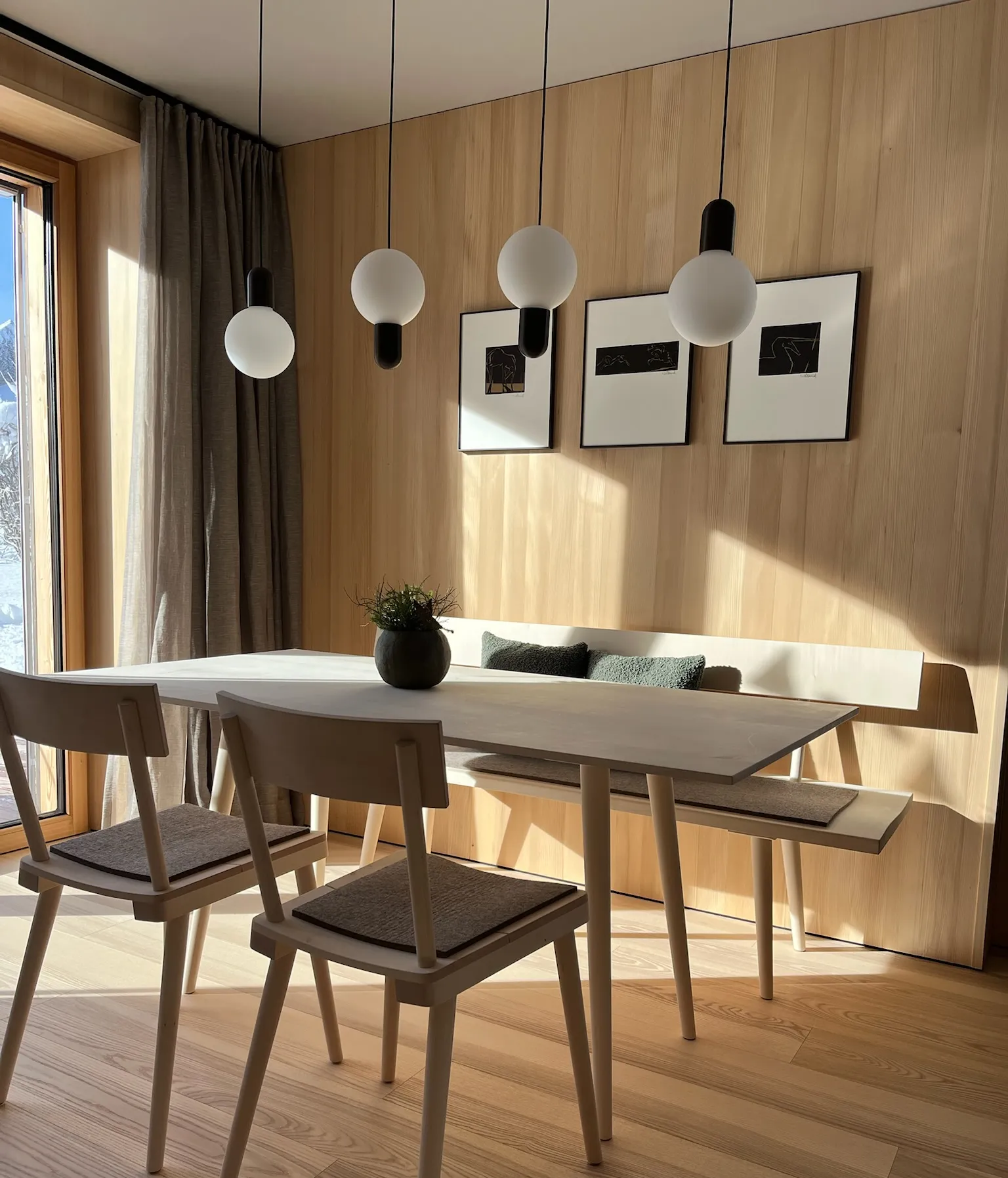 Blick durch die Holzlamellen ins Wohnzimmer mit Bergpanorama