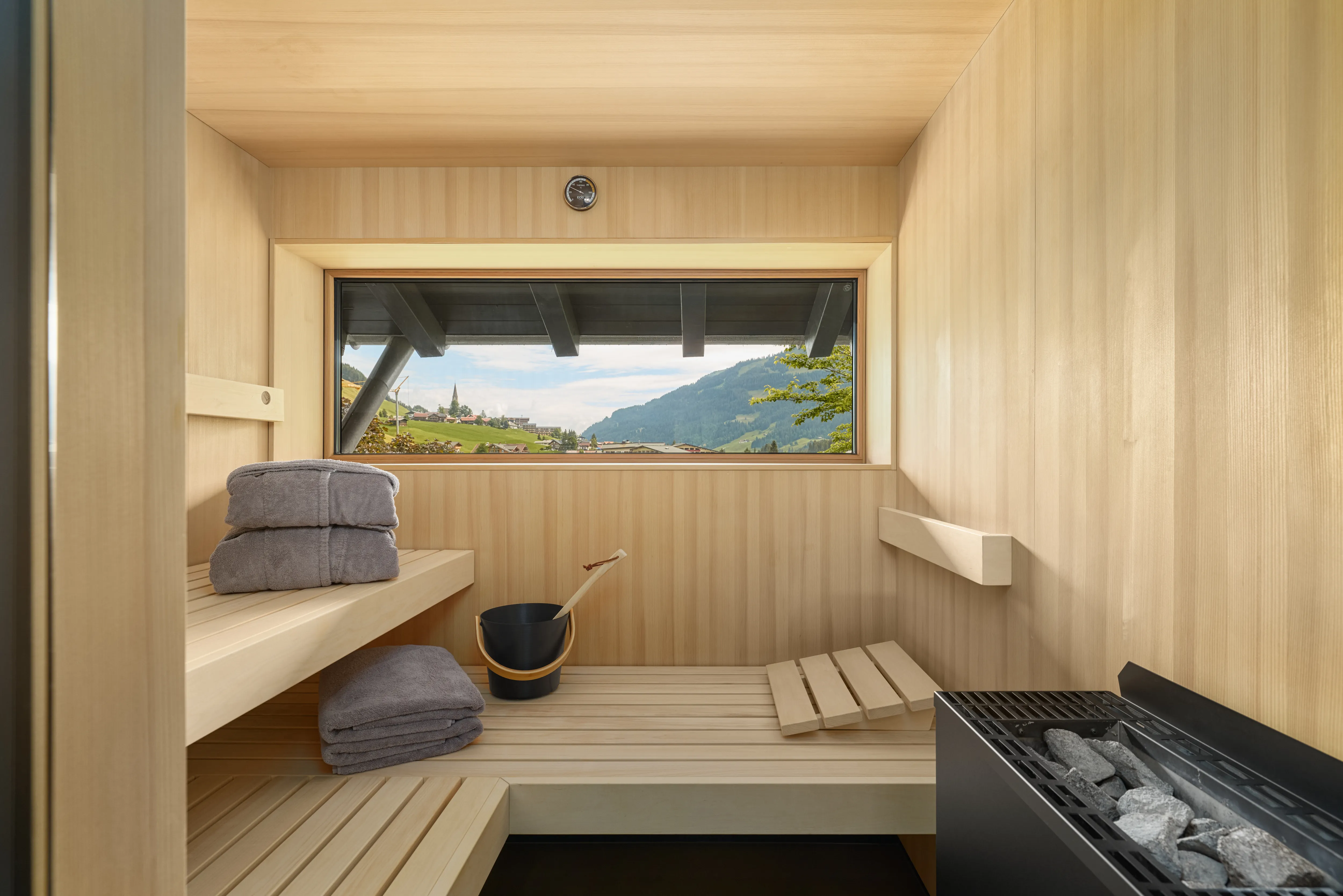 Finnische Sauna aus heimischem Holz mit Panoramafenster und Bergblick