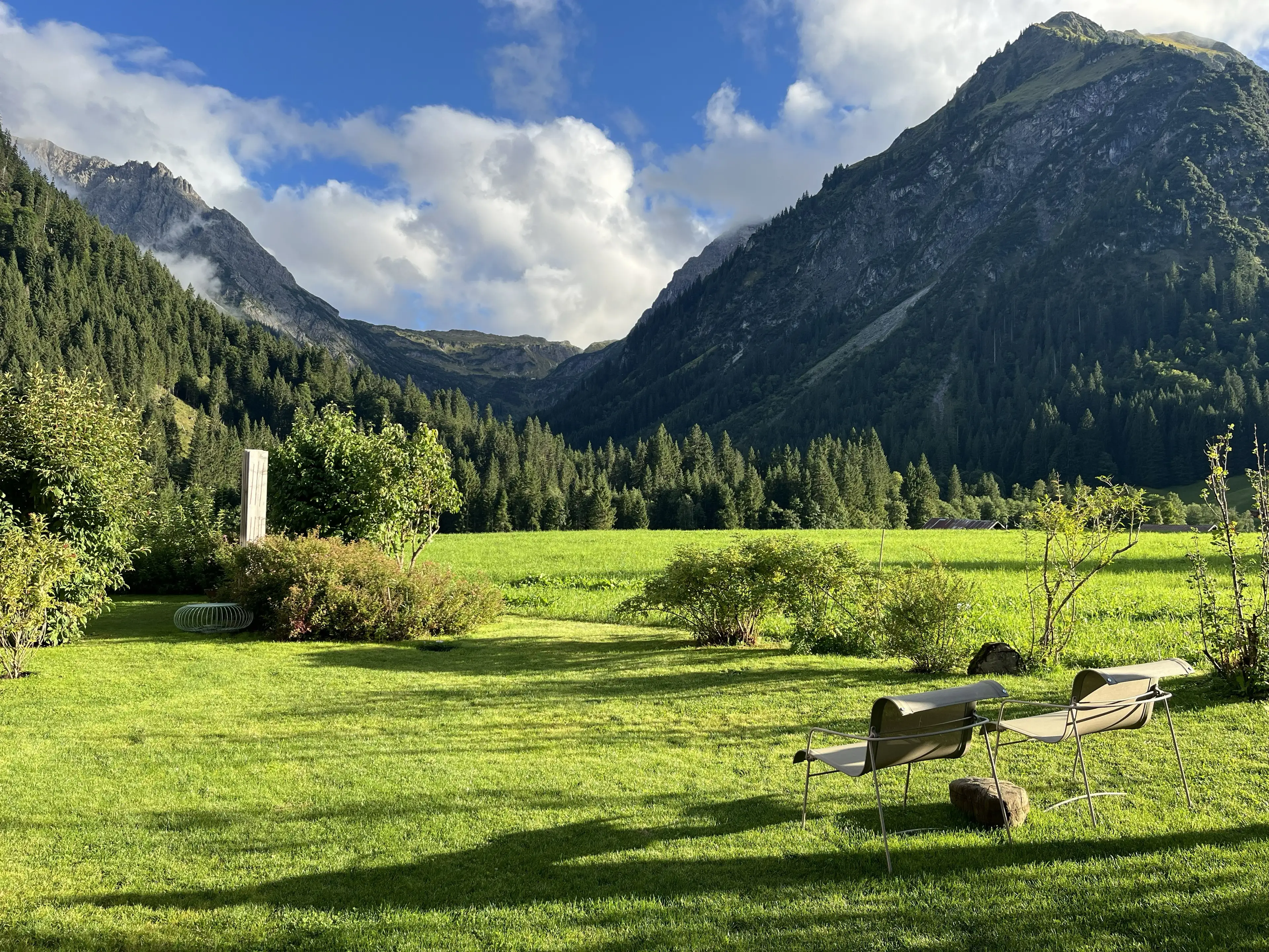 Ferienwohnung HEIMET im Kleinwalsertal — Garten mit Liegestühlen und Blick auf das Bergpanorama